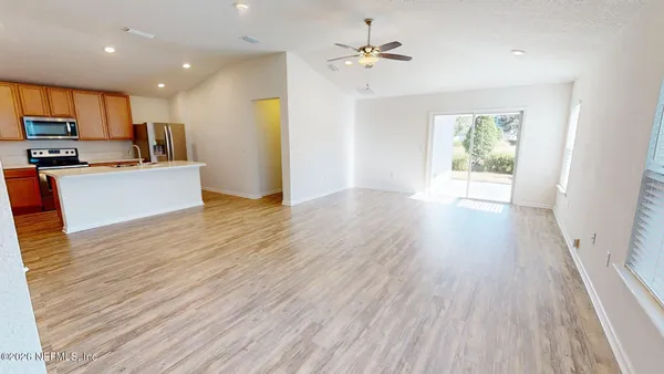 a view of kitchen with cabinets stainless steel appliances and wooden floor