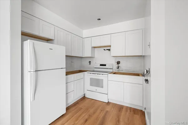 a kitchen with stainless steel appliances a refrigerator sink and white cabinets