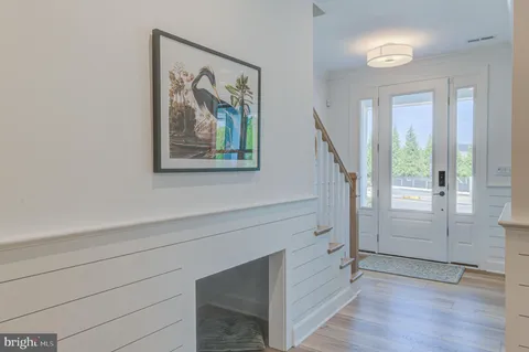 a view of hallway with window and wooden floor