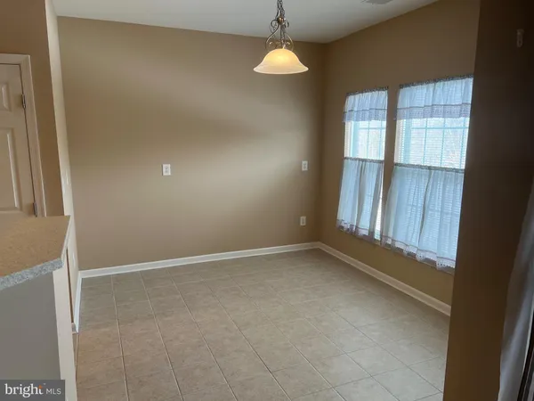 en empty room with windows and chandelier fan