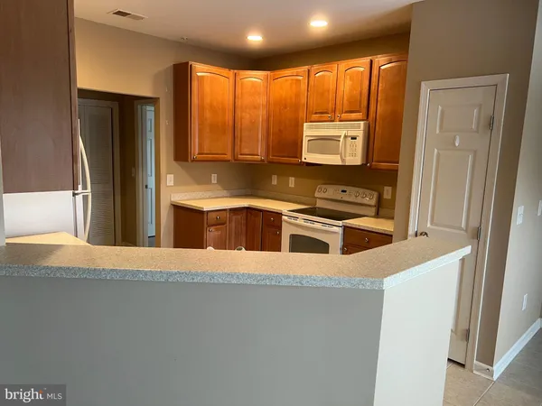 a kitchen with stainless steel appliances granite countertop a refrigerator a stove a sink and a microwave