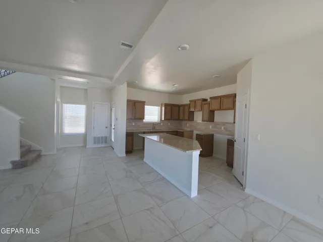 a large white kitchen with a sink and cabinets