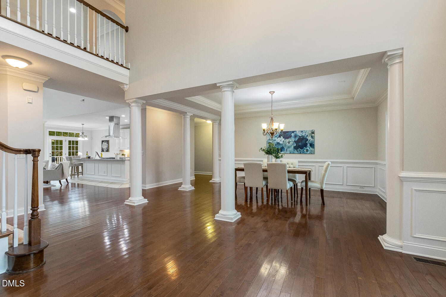 404 Vintage Hill Circle Apex, NC 27539 - Photo 11 of 82 a dining room with wooden floor a chandelier a glass table and chairs