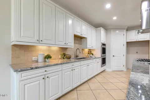 a bathroom with a granite countertop double vanity sink and a bathtub