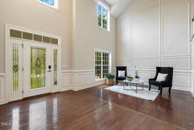 a dining room with furniture a chandelier and wooden floor