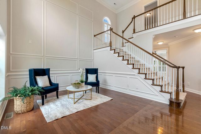 a dining room with wooden floor a chandelier a wooden table and chairs