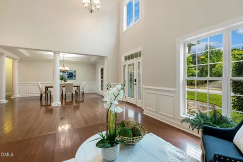 a dining room with furniture a chandelier and wooden floor