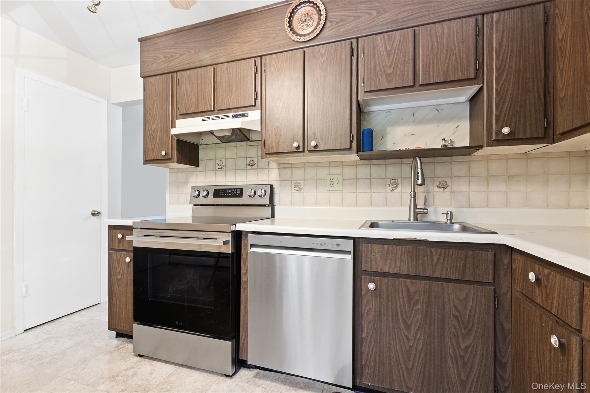 1840 Crompond Road, Unit 5C2 Peekskill, NY 10566 - Photo 8 of 27 a kitchen with stainless steel appliances granite countertop a sink stove and microwave