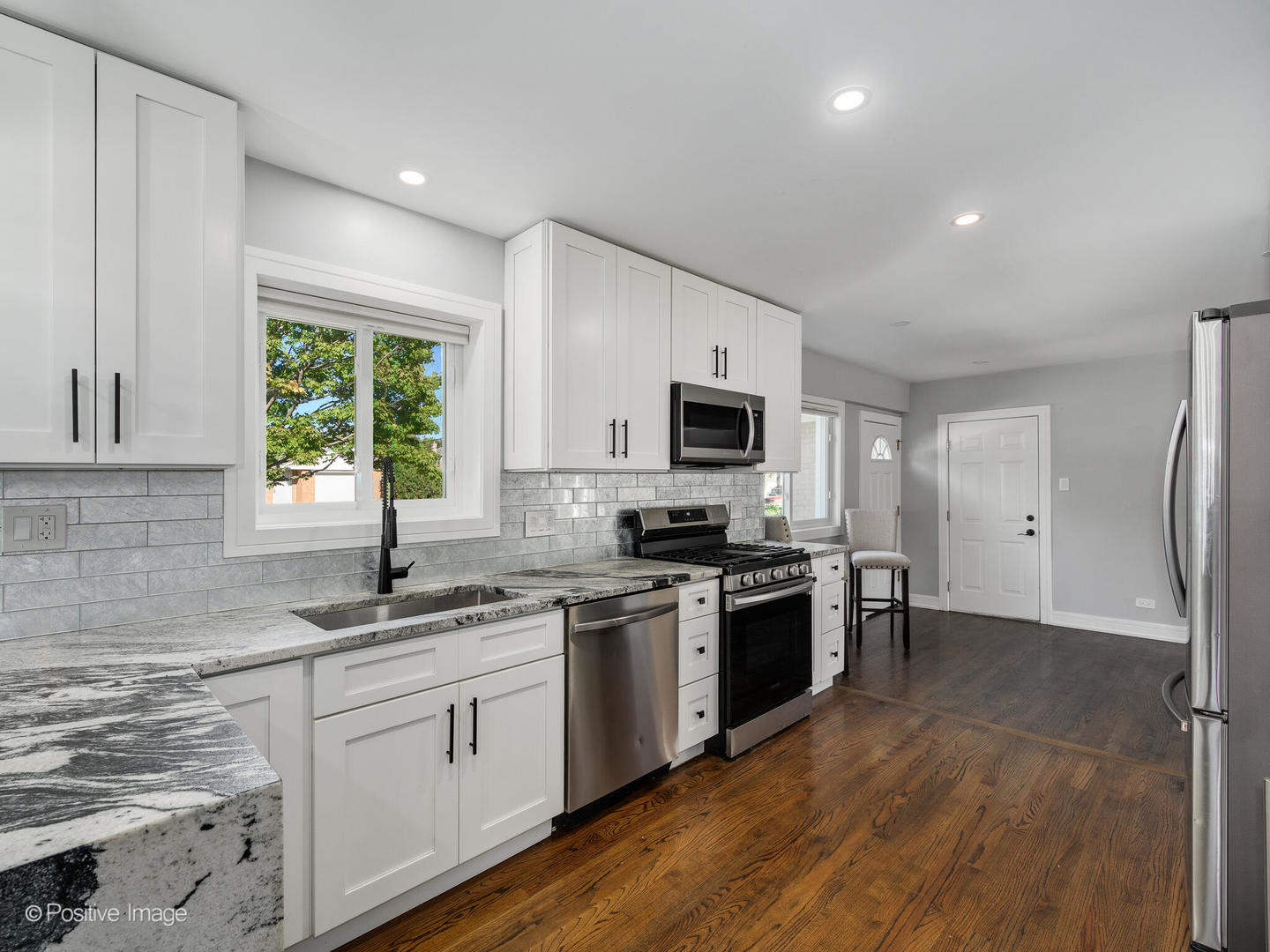 7225 East Prairie Road Lincolnwood, IL 60712 - Photo 15 of 27 a kitchen with stainless steel appliances granite countertop a sink a stove a refrigerator and a microwave