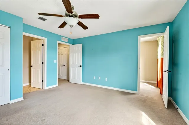 an empty room with closet and fan