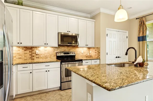 a kitchen with white cabinets a sink and dishwasher
