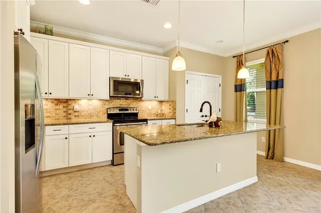 a kitchen with granite countertop a sink stove and refrigerator