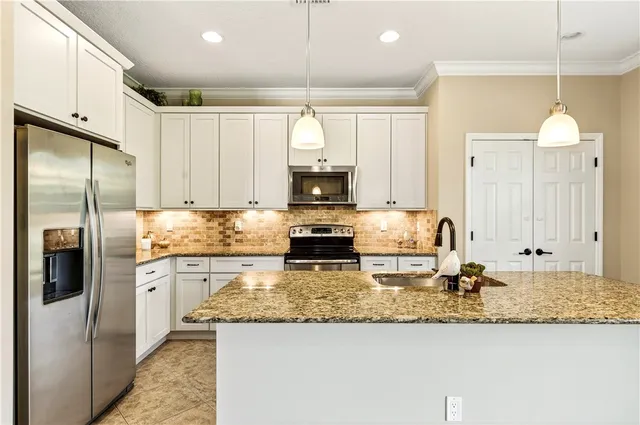 a kitchen with kitchen island granite countertop cabinets and refrigerator