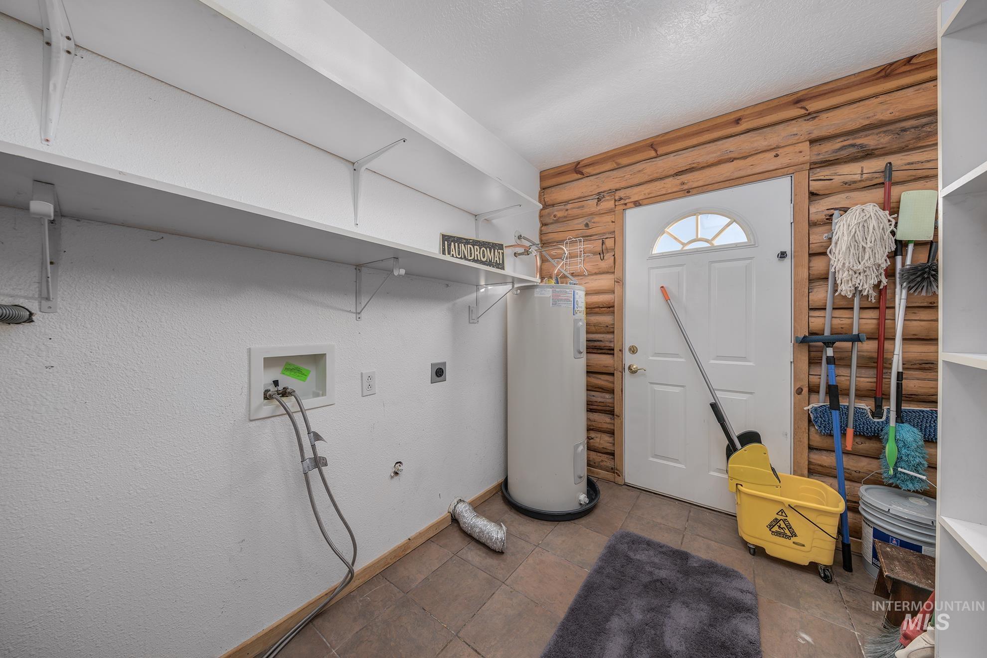 1855 Jones Road Weiser, ID 83672 - Photo 17 of 34 Laundry area featuring log walls, hookup for an electric dryer, water heater, washer hookup, and a textured ceiling