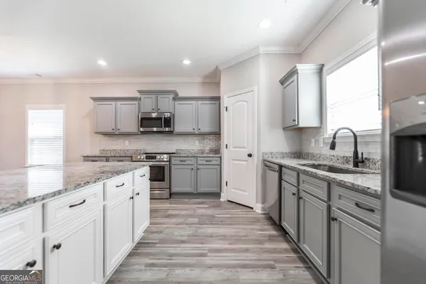 a kitchen with stainless steel appliances granite countertop a sink and cabinets