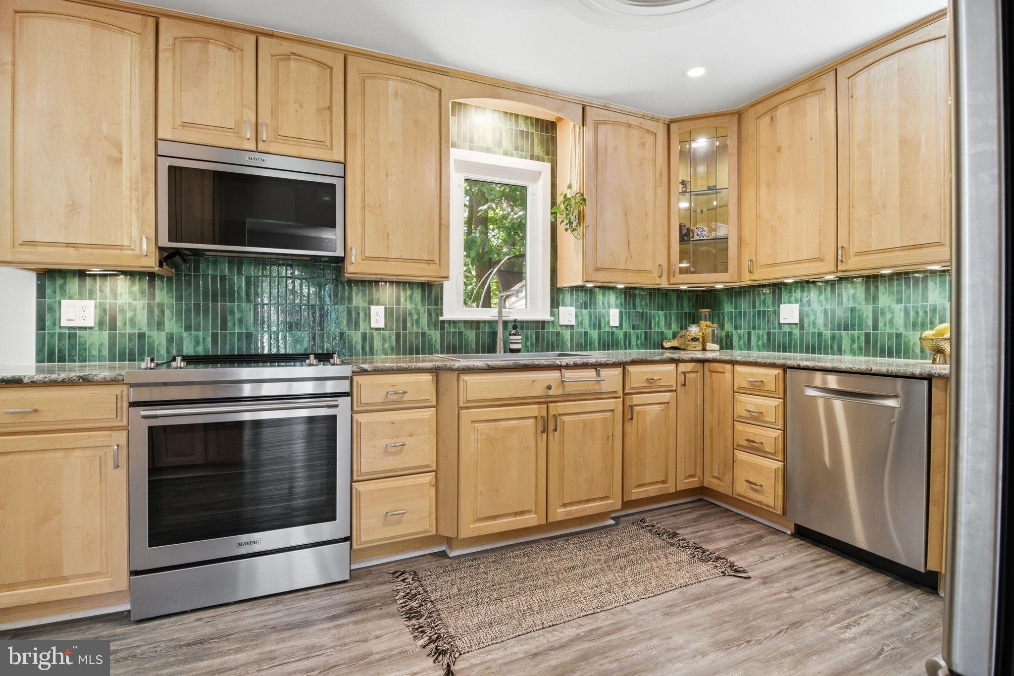 407 Autumn Olive Way Sterling, VA 20164 - Photo 12 of 47 a kitchen with granite countertop white cabinets stainless steel appliances and a sink