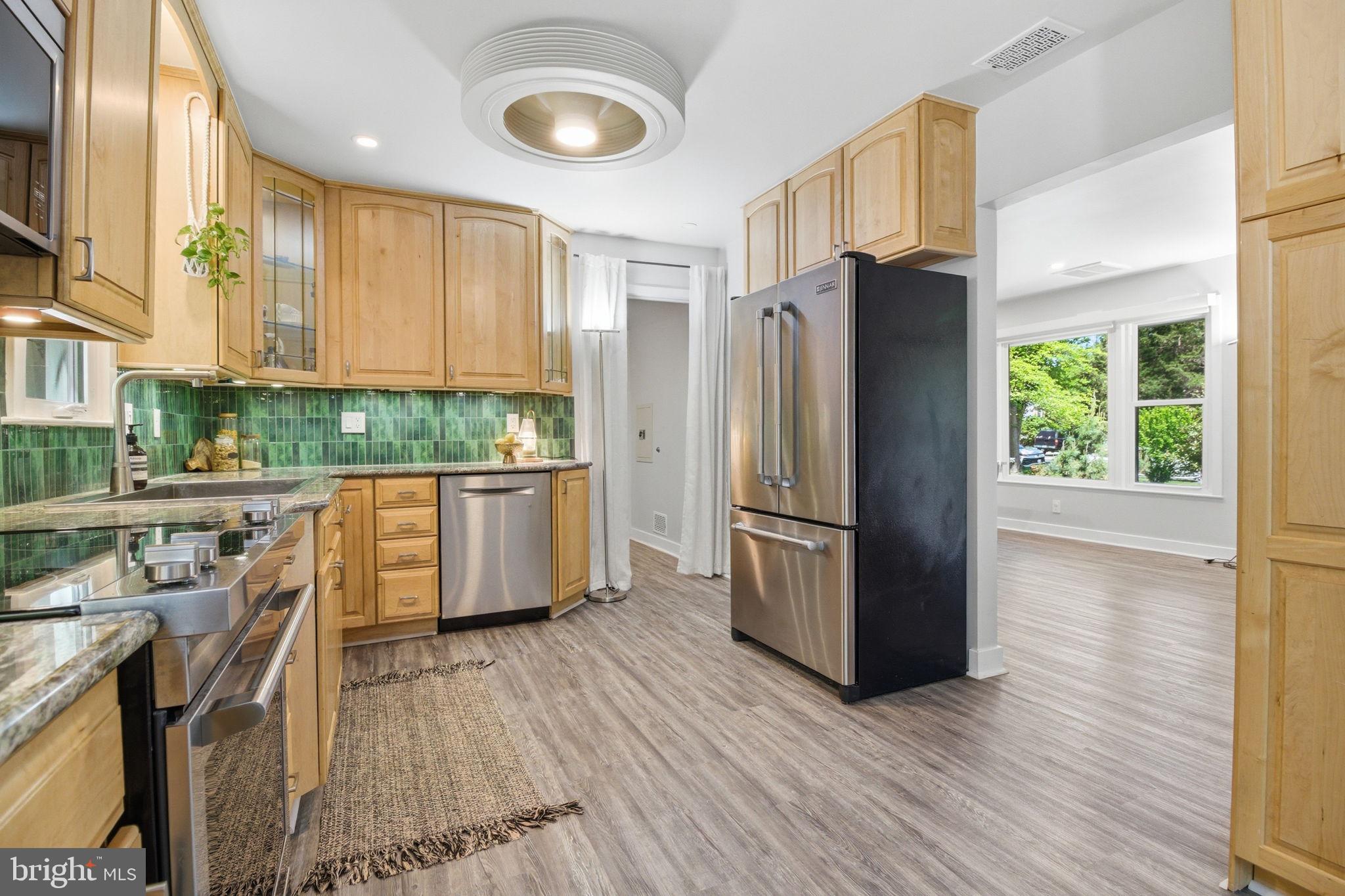407 Autumn Olive Way Sterling, VA 20164 - Photo 13 of 47 a kitchen with stainless steel appliances a refrigerator a sink a stove a refrigerator cabinets and wooden floor