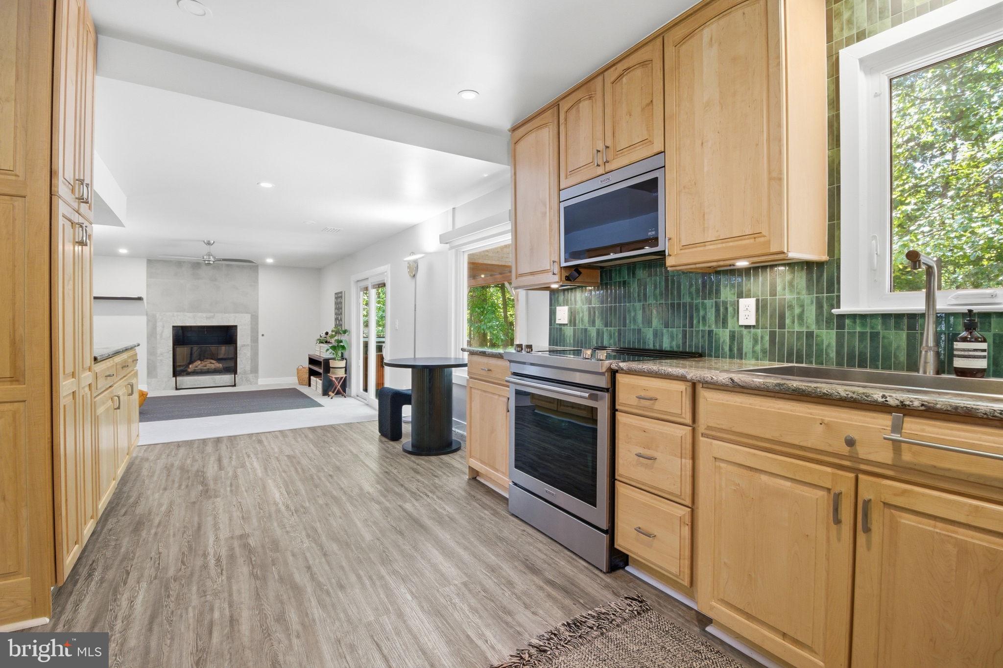407 Autumn Olive Way Sterling, VA 20164 - Photo 15 of 47 a kitchen with stainless steel appliances granite countertop a refrigerator a sink dishwasher a stove and a dining table with wooden floor