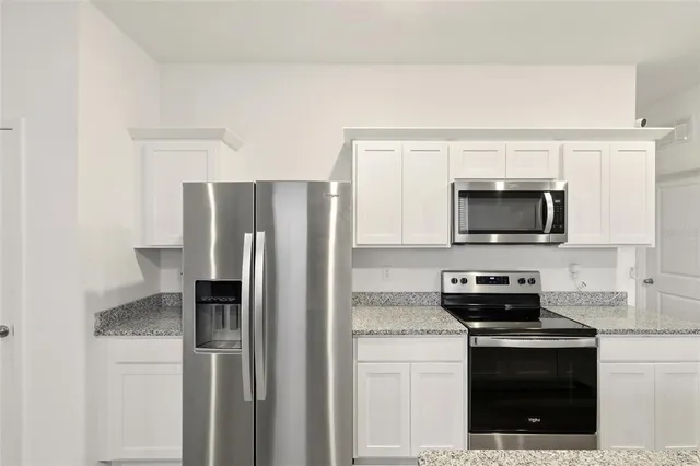 a kitchen with stainless steel appliances a refrigerator stove and microwave