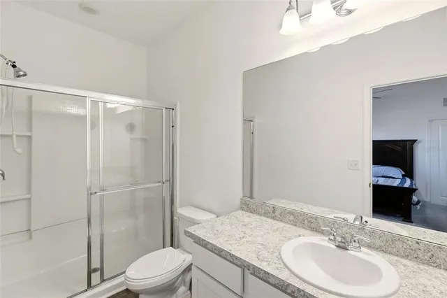 a bathroom with a granite countertop sink toilet and shower