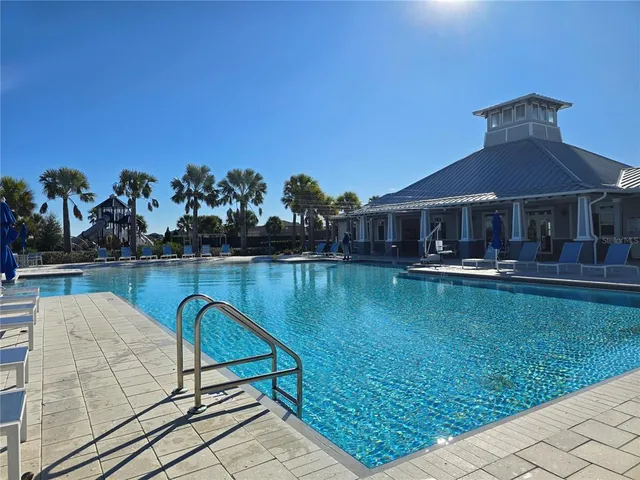 a swimming pool with outdoor seating yard and lake view