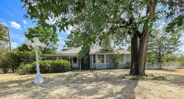 a view of a house with a tree in front of it