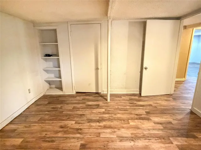 an empty room with wooden floor and a window