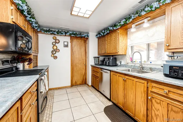 a kitchen with stainless steel appliances granite countertop a stove a sink dishwasher and a microwave oven with cabinets