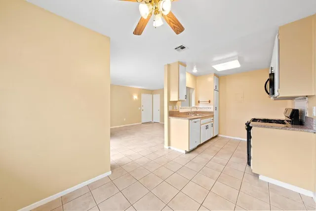 a kitchen with granite countertop white cabinets and white appliances