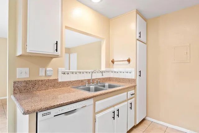 a kitchen with granite countertop a sink and a wooden cabinets