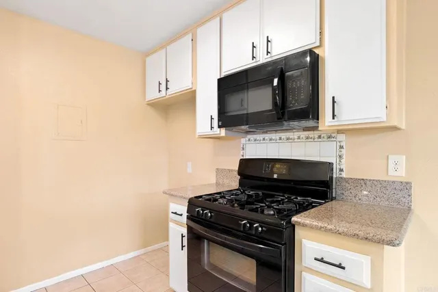 a kitchen with microwave stove and cabinets