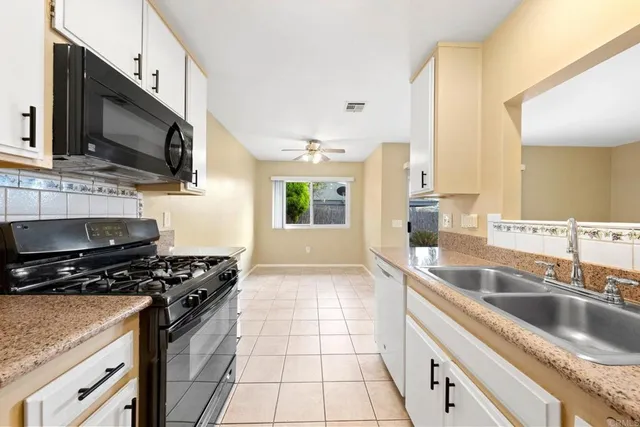 a kitchen with stainless steel appliances granite countertop a sink a stove top oven a counter space and cabinets