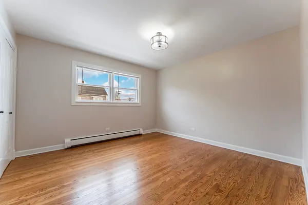 an empty room with wooden floor and a window