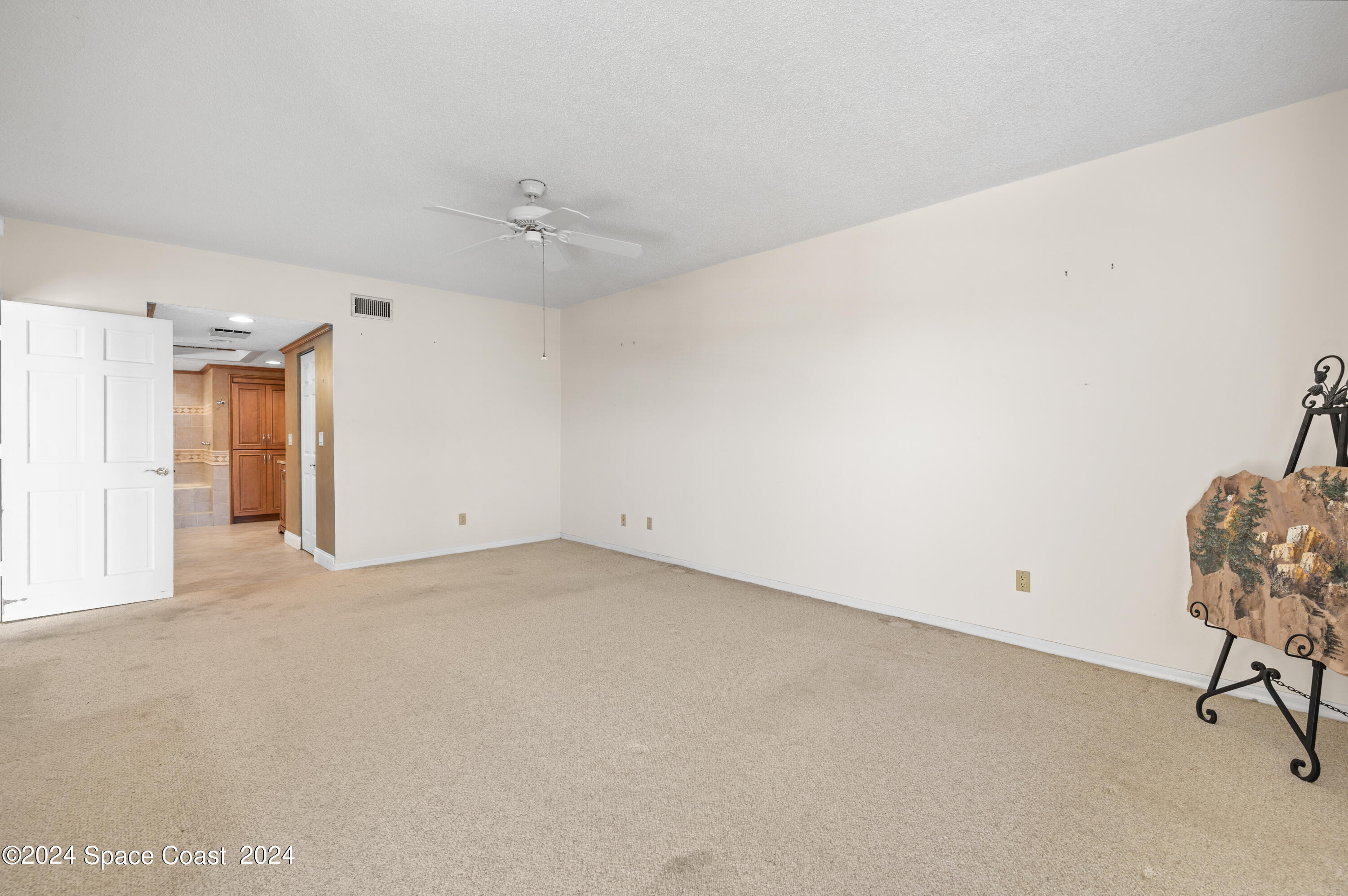 750 North Atlantic Avenue, Unit 608 Cocoa Beach, FL 32931 - Photo 13 of 39 an empty room with chandelier fan and windows