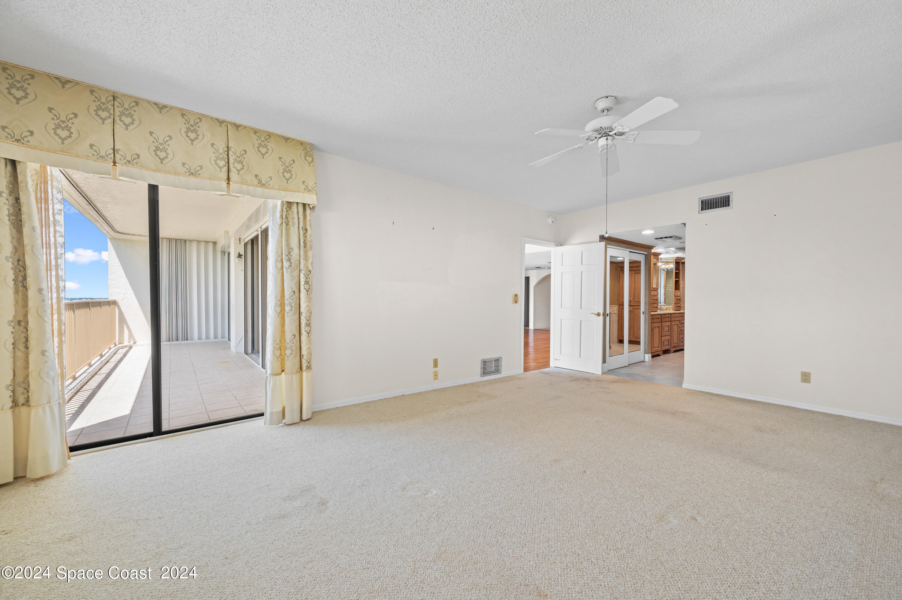 750 North Atlantic Avenue, Unit 608 Cocoa Beach, FL 32931 - Photo 14 of 39 a view of a big room with entryway and chandelier