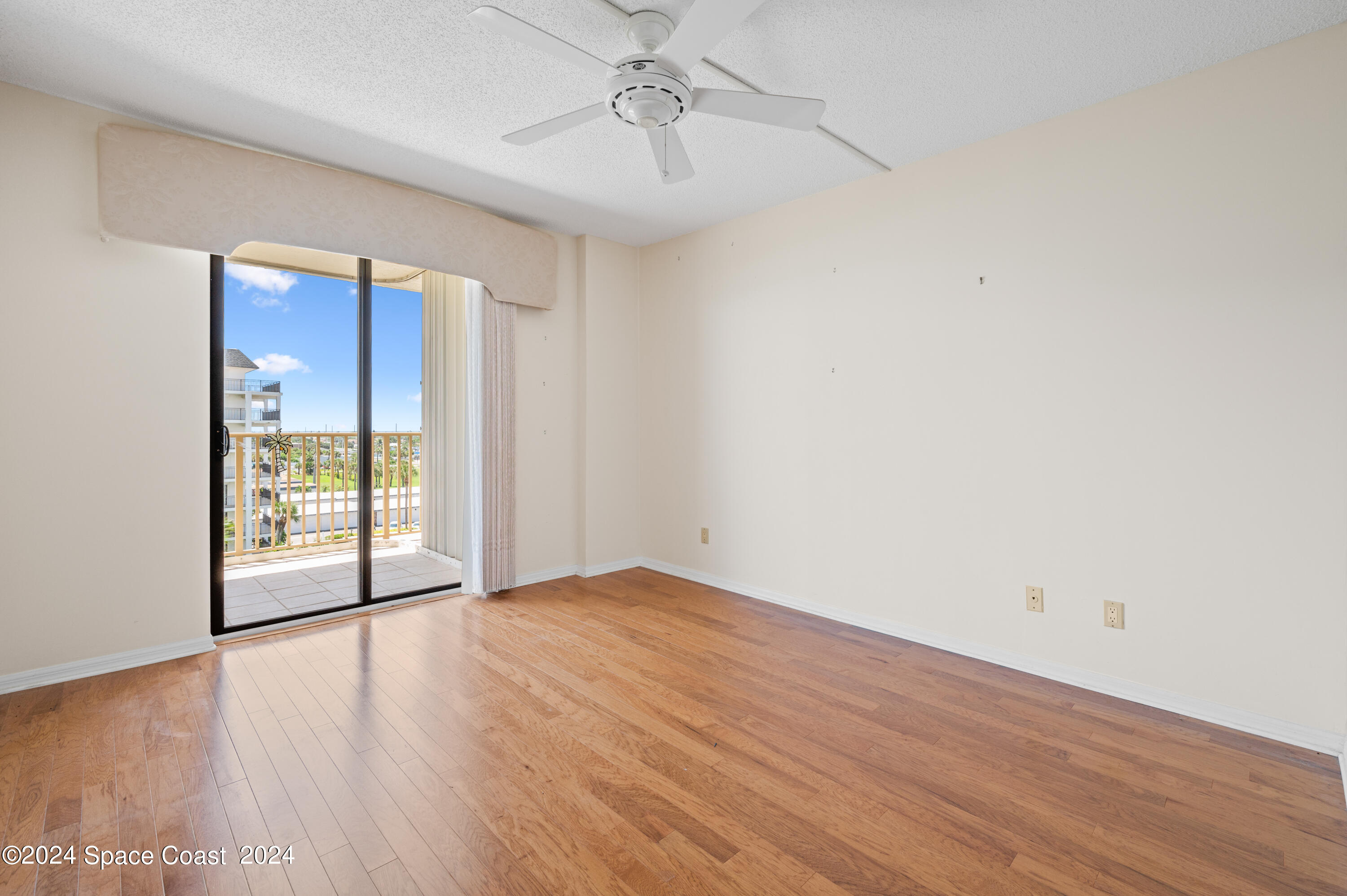 750 North Atlantic Avenue, Unit 608 Cocoa Beach, FL 32931 - Photo 24 of 39 a view of an empty room with wooden floor and a window