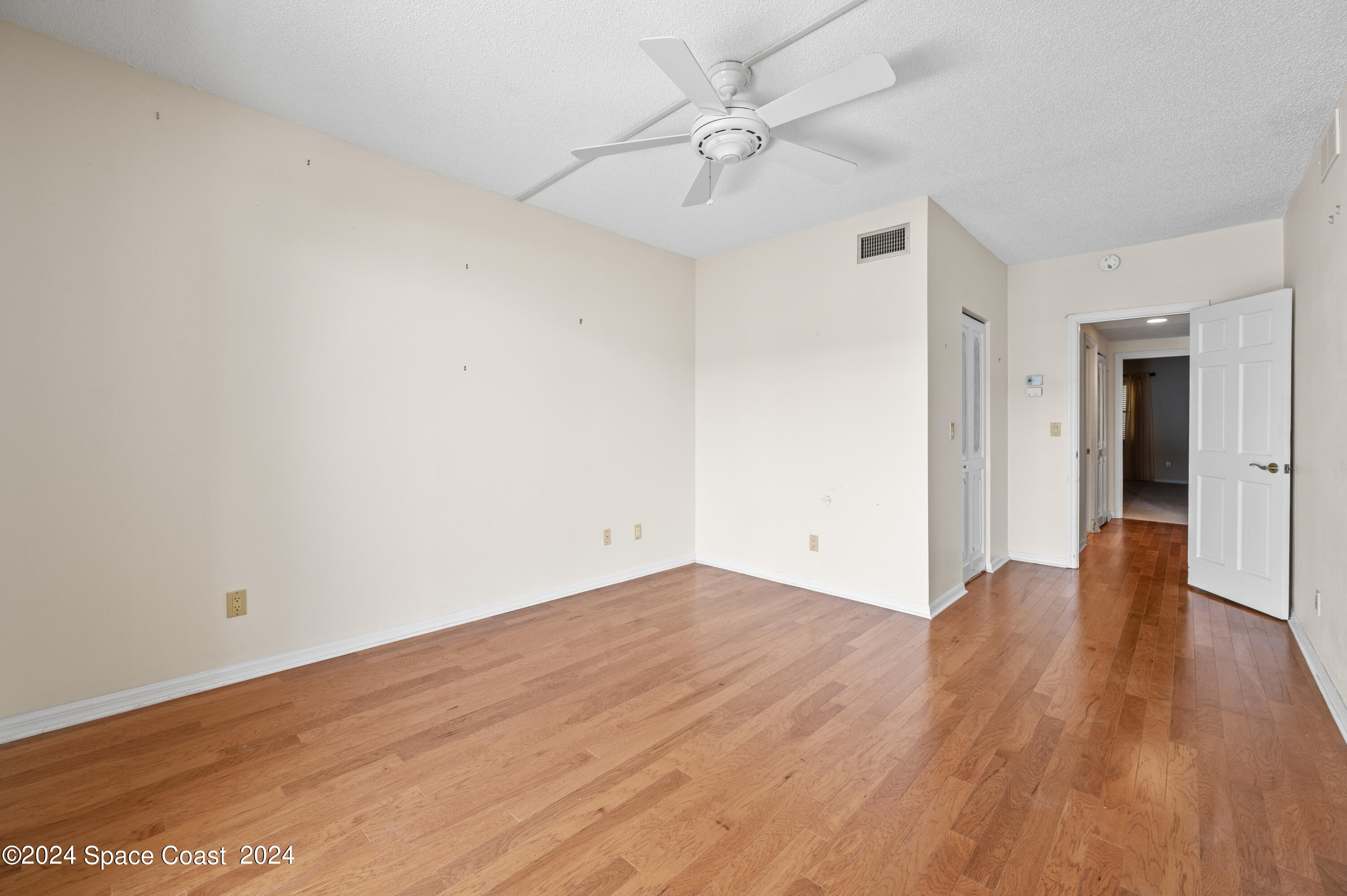 750 North Atlantic Avenue, Unit 608 Cocoa Beach, FL 32931 - Photo 25 of 39 an empty room with wooden floor and ceiling fan