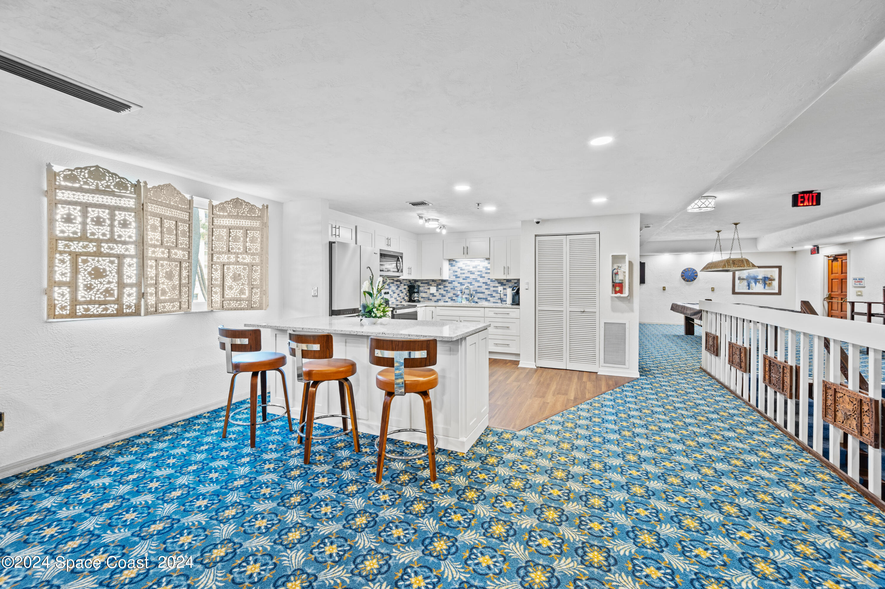 750 North Atlantic Avenue, Unit 608 Cocoa Beach, FL 32931 - Photo 33 of 39 a dining hall with stainless steel appliances granite countertop a rug a stove a sink and a dining table with wooden floor