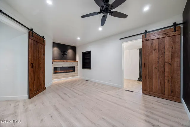 an empty room with wooden floor cabinet and windows