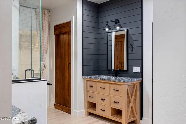 a bathroom with a granite countertop sink and a mirror