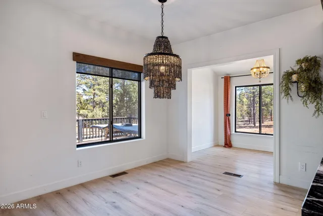 a view of a room with wooden floor fan and windows