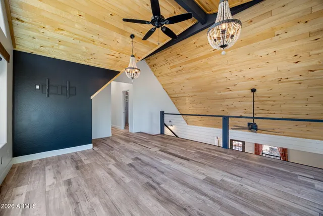 an empty room with wooden floor closet and windows