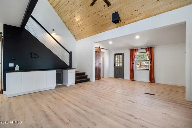 a view of an empty room with window and wooden floor
