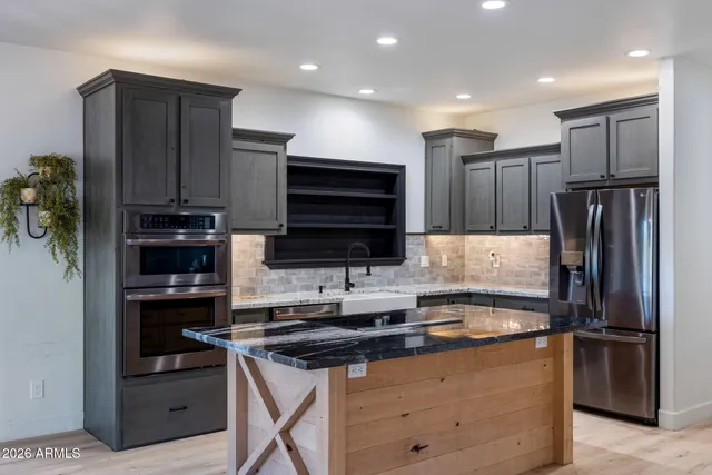 a kitchen with stainless steel appliances granite countertop a refrigerator and a stove top oven