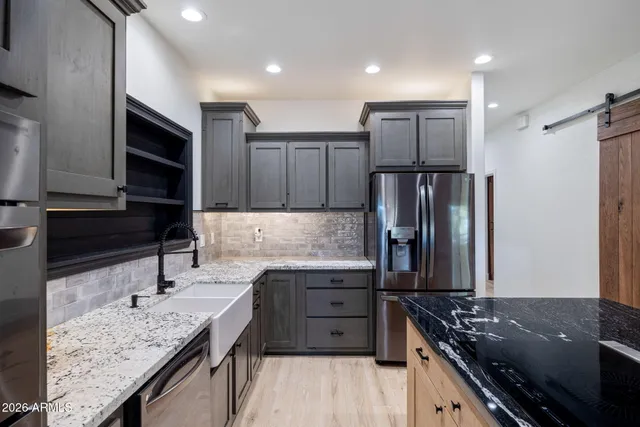 a kitchen with stainless steel appliances granite countertop a sink stove and refrigerator
