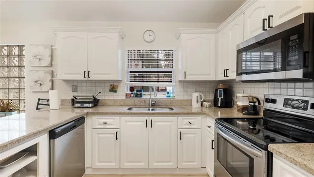 a kitchen with cabinets stainless steel appliances and a sink