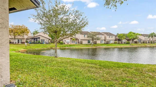 a view of an house with backyard and a tree