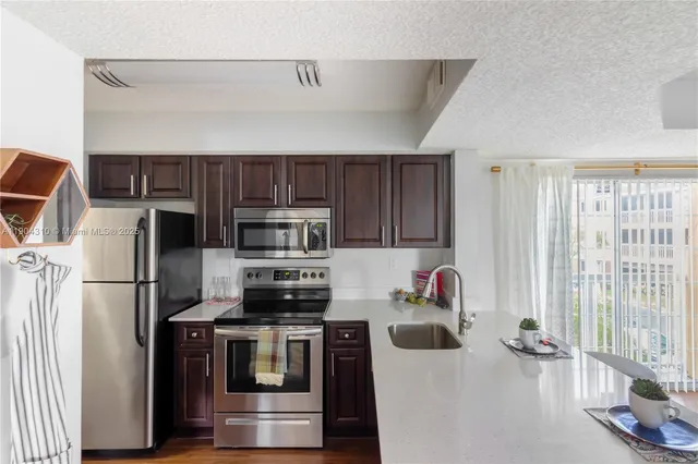 a kitchen with stainless steel appliances a stove a refrigerator and a microwave
