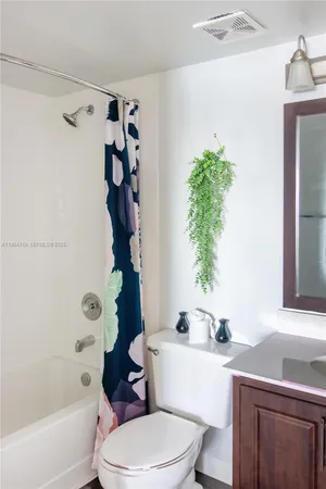 a bathroom with a sink a toilet a window and shower
