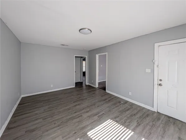 a view of an empty room with wooden floor